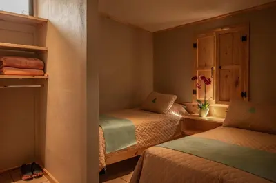 a bedroom with two beds and a window at Coffee Pickers Village By Hacienda Orosi in Cartago