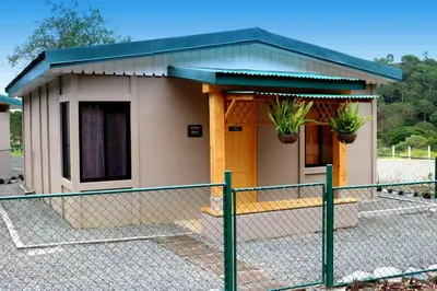 a small house with a fence in front of it at Coffee Pickers Village By Hacienda Orosi in Cartago