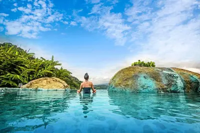 a man in the water in a swimming pool at Coffee Pickers Village By Hacienda Orosi in Cartago