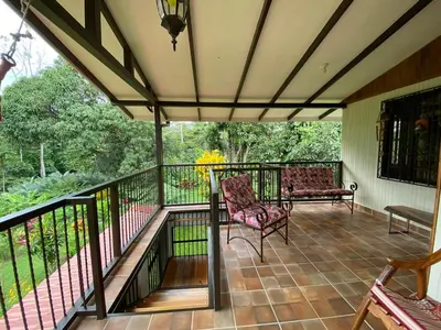 a covered porch with a chair and a couch at Serenity in Fortuna