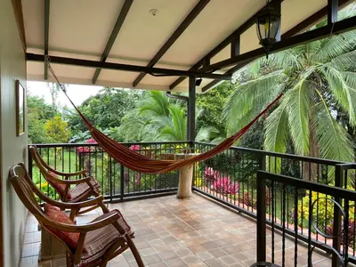 a hammock on a balcony with a palm tree at Serenity in Fortuna
