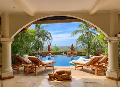 an archway over a swimming pool in a resort at Los Altos de Eros - Adults Only in Playa Avellana