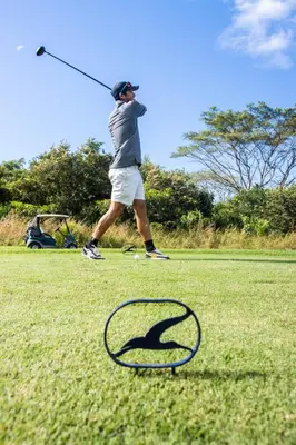 a man hitting a golf ball with a club at Hacienda Pinilla Vacation Rentals in Tamarindo