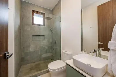 a bathroom with a toilet and a sink and a shower at Hacienda Pinilla Vacation Rentals in Tamarindo