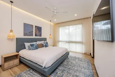 a bedroom with a bed and a large window at Hacienda Pinilla Vacation Rentals in Tamarindo