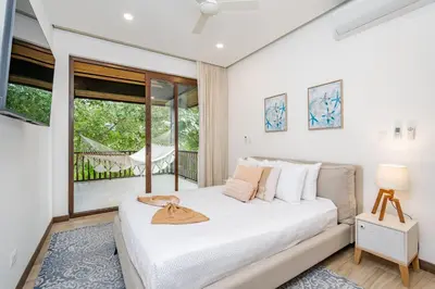 a bedroom with a bed and a balcony at Hacienda Pinilla Vacation Rentals in Tamarindo