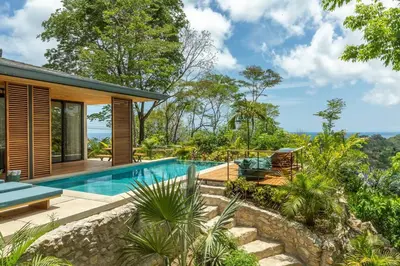 a home with a swimming pool and a house at The L Design Villa in Carmen