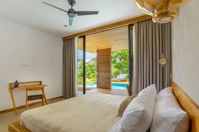 a bedroom with a bed and a desk and a pool at The L Design Villa in Carmen