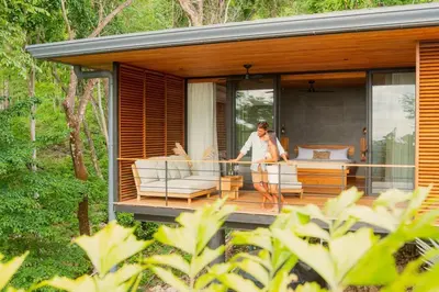 a woman standing on the deck of a house at The L Design Villa in Carmen