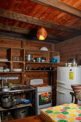 a kitchen with a stove and a refrigerator at Cabaña Ave Del Paraiso in Cartago