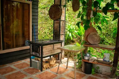 an outdoor grill and a table on a patio at Cabaña Ave Del Paraiso in Cartago
