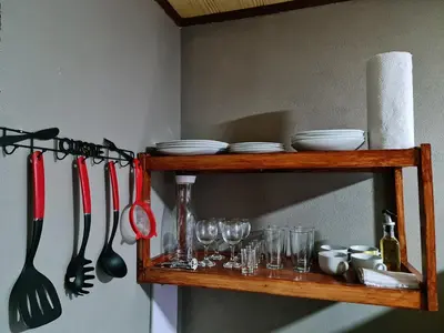 a wooden shelf with dishes and utensils on it at Cabinas Guayabón #3, AC, La Fortuna Volcán Arenal in Fortuna
