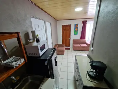 a small kitchen with a sink and a microwave at Cabinas Guayabón #3, AC, La Fortuna Volcán Arenal in Fortuna