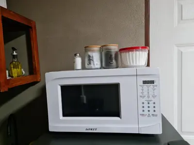 a white microwave sitting on top of a counter at Cabinas Guayabón #3, AC, La Fortuna Volcán Arenal in Fortuna