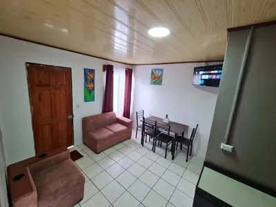 a living room with a couch and a dining room table at Cabinas Guayabón #3, AC, La Fortuna Volcán Arenal in Fortuna