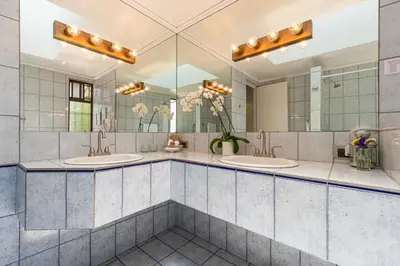 a bathroom with two sinks and a large mirror at Posada el Quijote in San José