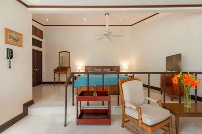 a living room with a bed and a table and a chair at Posada el Quijote in San José
