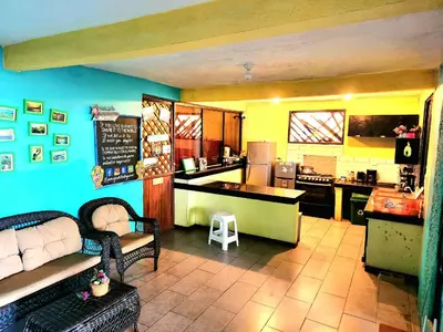 a kitchen with a table and a counter in a kitchen at Tortuguero Adventures Beach House in Tortuguero