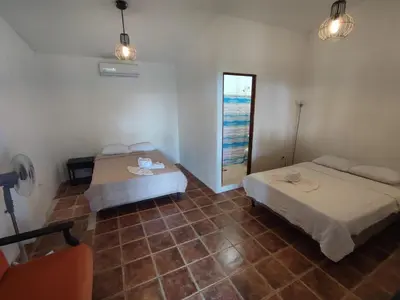 a room with two beds and a window in it at Hostel Plinio in Manuel Antonio