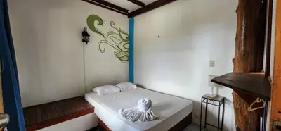 a small room with a bed in the corner at Hostel Plinio in Manuel Antonio