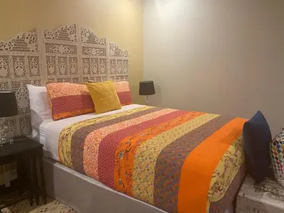 a bedroom with a bed with an orange and yellow blanket at CASA DEL LAGO in Cachí