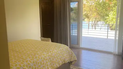 a bedroom with a bed and a large sliding glass door at CASA DEL LAGO in Cachí