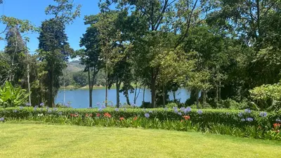 a garden with flowers and a lake in the background at CASA DEL LAGO in Cachí