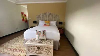 a bedroom with a large white bed and a stool at CASA DEL LAGO in Cachí