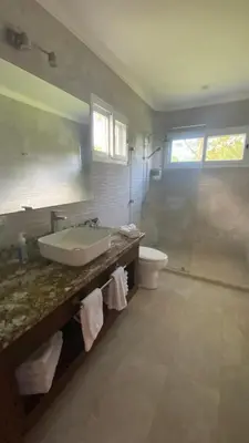 a bathroom with a sink and a toilet and a mirror at CASA DEL LAGO in Cachí