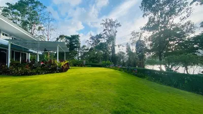 a yard with a house and a green lawn at CASA DEL LAGO in Cachí
