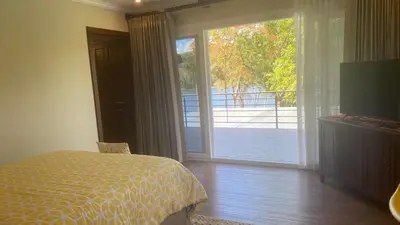 a bedroom with a bed and a sliding glass door at CASA DEL LAGO in Cachí