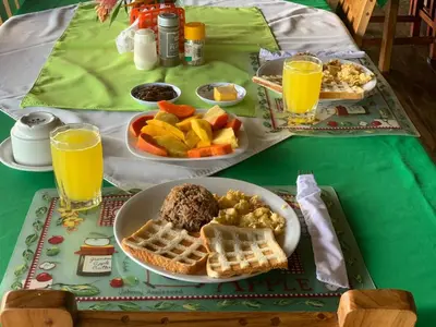 a table with two plates of breakfast foods and two glasses of orange juice at All Rankins Eco-Lodge in Tortuguero