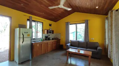 a kitchen with a refrigerator and a couch in a room at Casa Coco Playa Marbella with AC, Swimming Pool, Skate Bowl & walking distance Beach for Surfers and Nature Lovers in Marbella