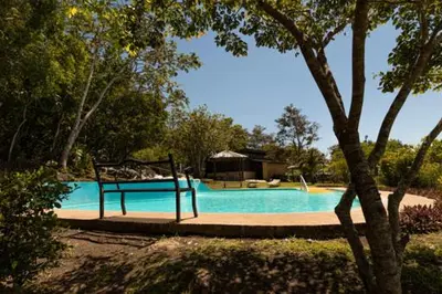 a bench sitting in front of a swimming pool at Colinas del Miravalles Hotel & Hot Springs in Hacienda Guayabo