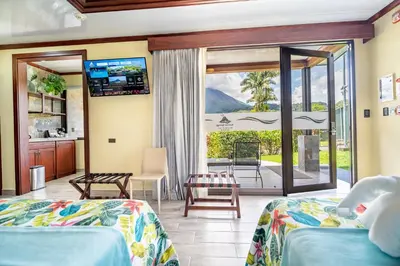 a hotel room with two beds and a balcony at Hotel Arenal Springs Resort & Spa in Fortuna