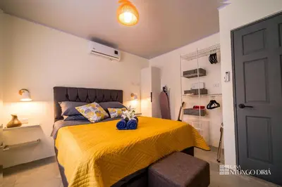 a bedroom with a bed with a yellow bedspread at Bungalow with private pool only 15min from Tamarindo Beach in Tamarindo
