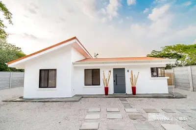 a white house with a fence in front of it at Bungalow with private pool only 15min from Tamarindo Beach in Tamarindo