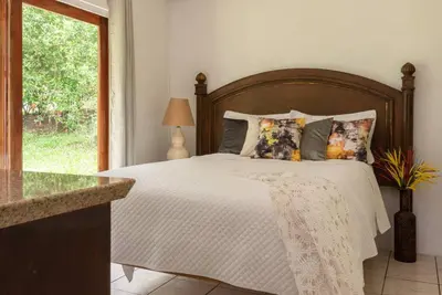 a bedroom with a large bed with a wooden headboard at Gateway to Paradise in Tilarán