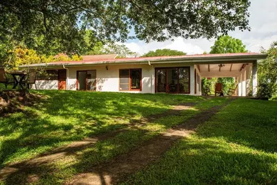 a house with a green lawn in front of it at Gateway to Paradise in Tilarán