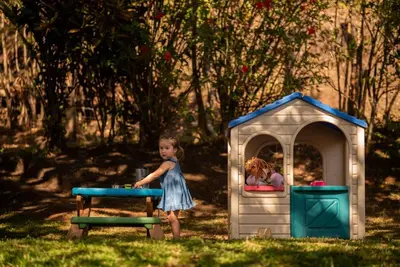 a little girl standing in front of a play house at Gateway to Paradise in Tilarán