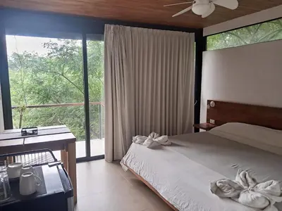 a bedroom with a bed and a desk and a window at Villa Gaspar Terrazas in Playa hermosa
