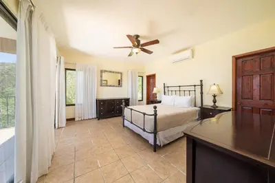 a bedroom with a bed and a ceiling fan at Vida de la Paz 4 - Oceanview Condo, 2BR, just remodeled, Playa Prieta in Potrero