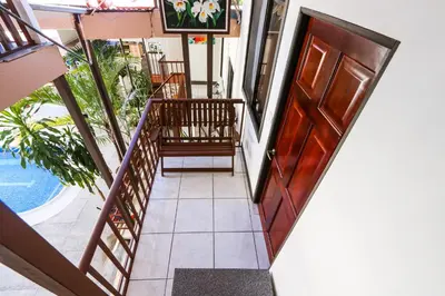 a stairway with a wooden door and a balcony at Hotel Flor Blanca in Manuel Antonio
