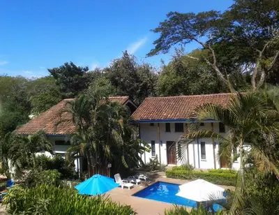 a house with a swimming pool in front of it at Tamarindo Blue Apartments in Tamarindo