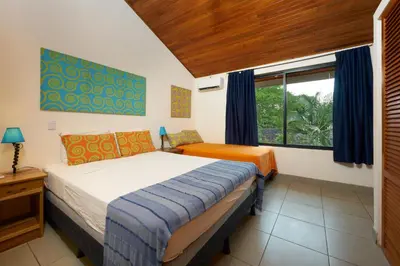 a bedroom with two beds and a window at Tamarindo Blue Apartments in Tamarindo