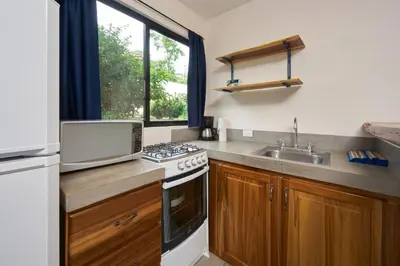 a kitchen with a sink and a stove at Tamarindo Blue Apartments in Tamarindo