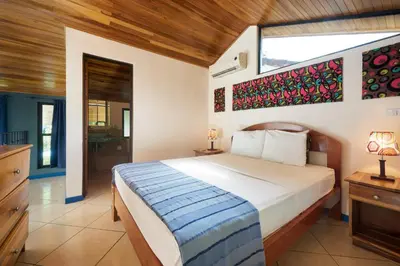 a bedroom with a large bed and a window at Tamarindo Blue Apartments in Tamarindo