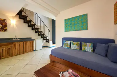 a living room with a blue couch and a staircase at Tamarindo Blue Apartments in Tamarindo