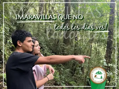 a man and a woman standing in front of a forest at Cabaña Montaña de Sueños in Quesada