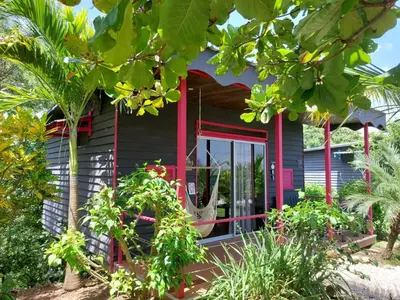 a house with a red front porch with plants at La Colina Pura Vista in Bejuco